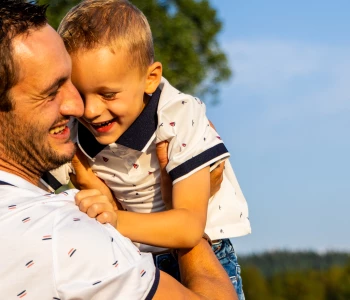 Papa portant son fils à bout de bras