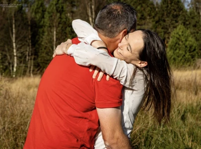 Femme souriante serrant son compagnon vêtu de rouge dans ses bras