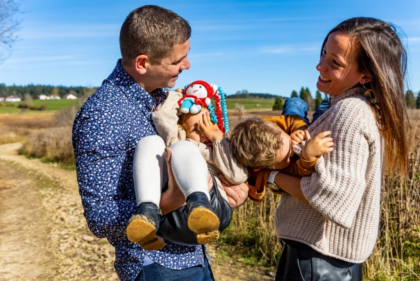 Deux enfants grimpant et riant dans un arbre au coucher du soleil